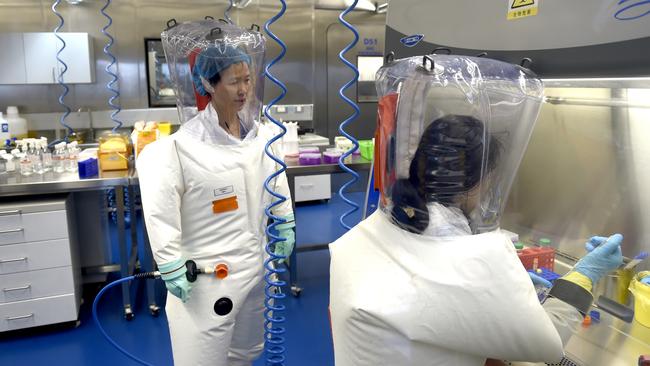 Virologist Shi Zhengli-li, left, works with a colleague in the P4 lab of Wuhan Institute of Virology. Picture: Getty Images