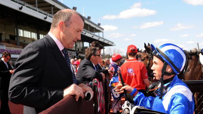 Dean Holland speaks to trainer David Hayes at Flemington.