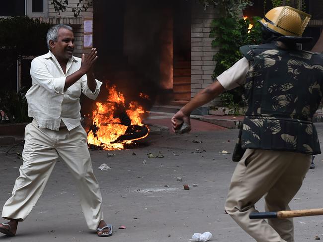 A follower of Indian religious leader Gurmeet Ram Rahim Singh pleads for his safety after being hit with a stick during clashes between the controversial guru's followers and security forces in Panchkula. Picture: AFP