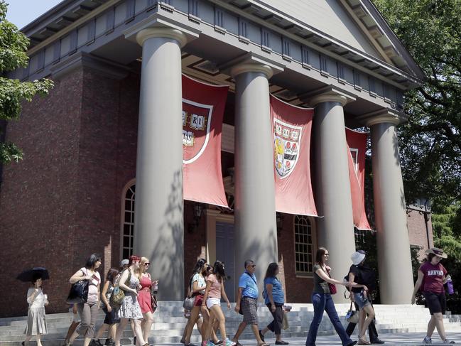 FILE - In this Aug. 30, 2012, file photo, a tour group walks through the campus of Harvard University in Cambridge, Mass. School officials said Wednesday, June 3, 2015, that Harvard Business School graduate and prominent Wall Street investor John Paulson donated $400 million to the school, its biggest gift in its history. Harvard said the endowment will support the School of Engineering and Applied Sciences, which will be renamed the Harvard John A. Paulson School of Engineering and Applied Sciences in his honor. (AP Photo/Elise Amendola, File)