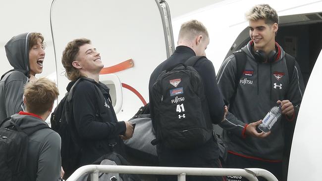 Essendon players Kobe Mutch, Josh Begley, Brayden Ham, Cian McBride and Brandon Zerk-Thatcher wait to board their ride to Queensland. Picture: Getty Images