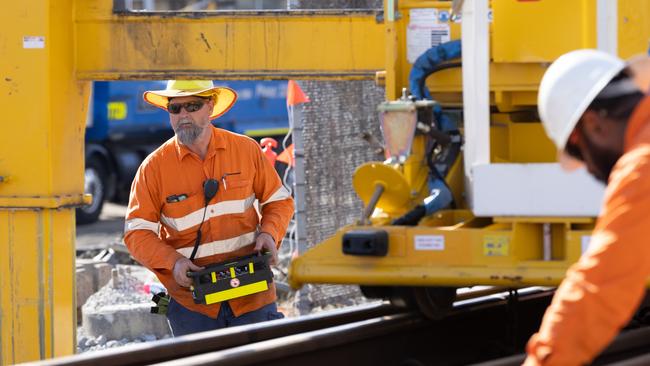 A Cross River Rail worker uses remote-controlled equipment to lay new tracks as part of the project.