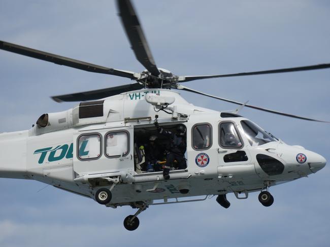 A medical team from the NSW Ambulance helicopter assisted in the treatment of a woman in her 70s after a car crashed into a brick fence at Narrabeen. Picture: Richard Noone