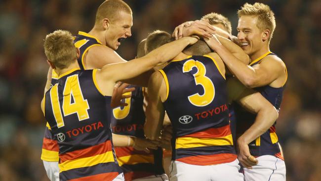 Adelaide players get around Tim McIntyre after his first goal. Picture: AAP Images