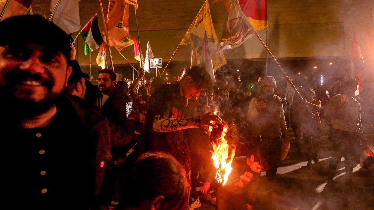 Supporters of pro-Iran factions wave various flags in Baghdad's Tahrir square, during a protest against the US and British forces strikes targeting Yemen's Huthi rebels, and against the presence of US forces in Iraq. Picture: Murtaja Lateef / AFP