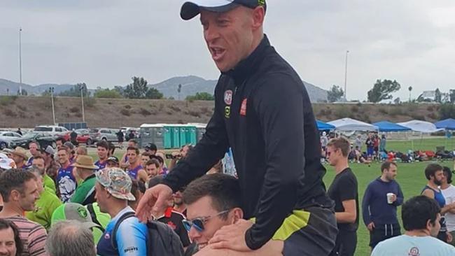 Collingwood tall Mason Cox gives AFL umpire Ray Chamberlain a shoulder ride at the USAFL Championships.