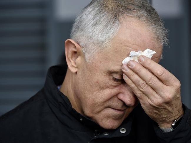 Prime Minister Malcolm Turnbull Election 2016. PM Malcolm Turnbull Visits a trucking company in Smeaton Grange with Michaelia Cash (In White jacket), Darren Chester, Marise Payne, Russel Mathieson, Craig Kelly and Liberal Canditate for Werriwa Ned Mannoun. Malcolm Turnbull wipes rain from his forehead. Picture: Jason Edwards