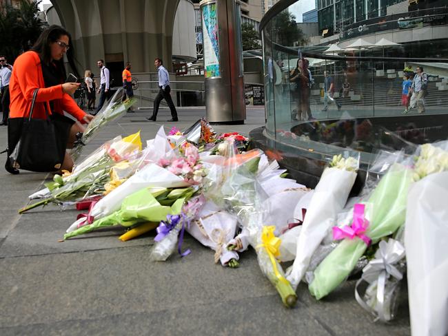 People lay flowers at a memorial in Martin Place after the siege ended. Picture: John Grainger