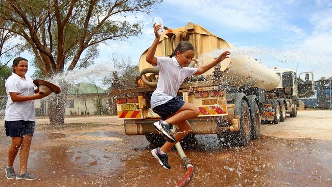 Sisters Kayla (13) and Ciara (10) Anderson make the most of the water delivery to Tottenham bowling club. Picture: Toby Zerna