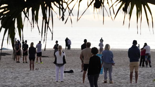 People commemorate Anzac Day at dawn on Currumbin Beach on the Gold Coast. Picture: Dave Hunt