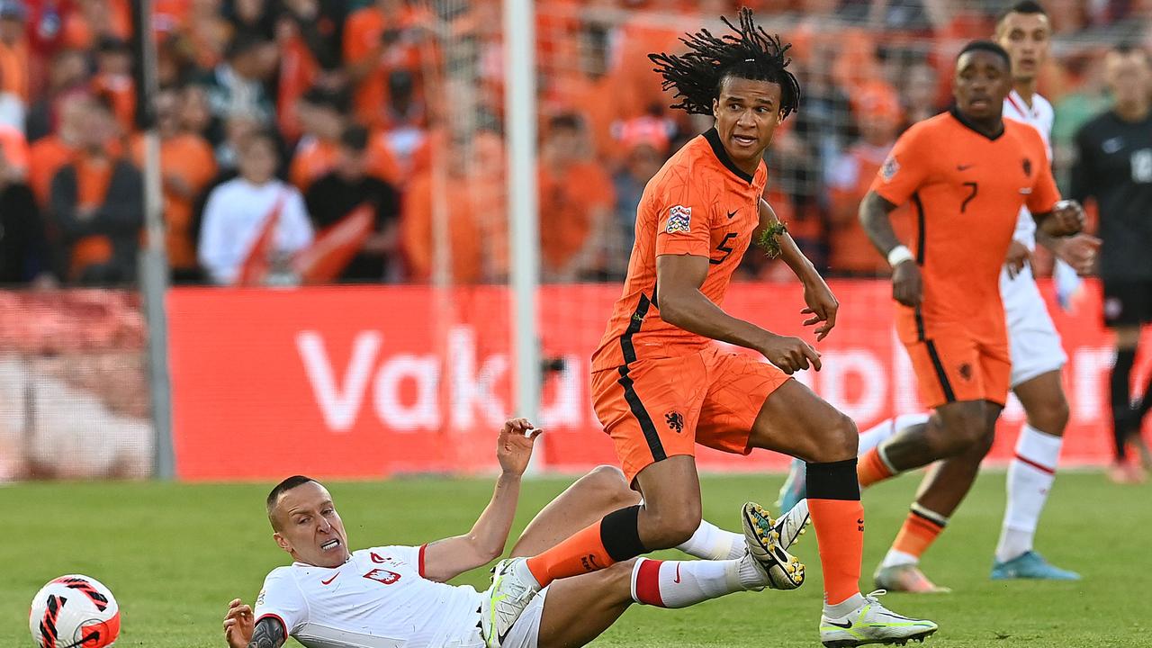Netherlands' defender Nathan Ake (C) fights for the ball with Poland's midfielder Jacek Goralski (L) during the UEFA Nations League, League A Group 4 football match between Netherlands and Poland at the Feyenoord "De Kuip" stadium in Rotterdam on June 11, 2022. (Photo by JOHN THYS / various sources / AFP)