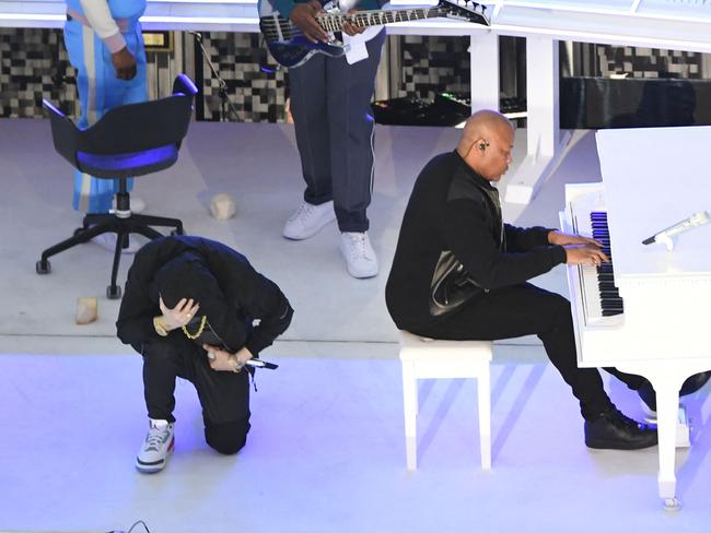 US rapper Eminem takes a knee as he performs during the halftime show. Picture: AFP