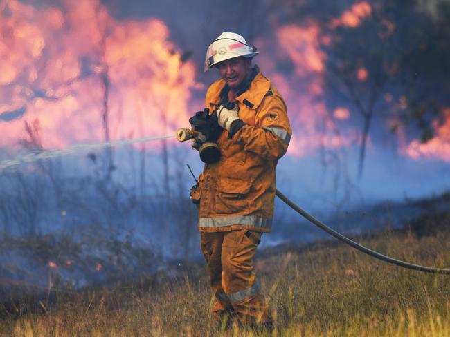 A rural firefighter battles flames.