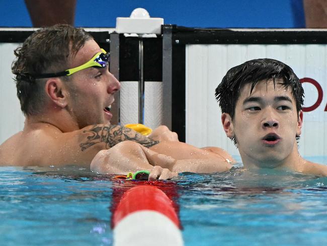 China's Pan Zhanle (R) celebrates next to Australia's Kyle Chalmers after winning the final of the men's 100m freestyle swimming event during the Paris 2024 Olympic Games at the Paris La Defense Arena in Nanterre, west of Paris, on July 31, 2024. (Photo by Jonathan NACKSTRAND / AFP)