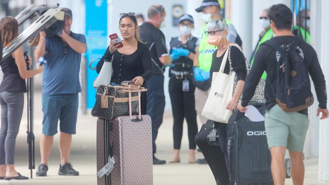 A passenger arriving at Darwin airport from interstate on Thursday makes her feelings on the new quarantine rules clear before the travellers were taken off to hotels. Picture Glenn Campbell