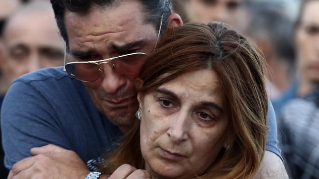 A man and woman comfort each other at a memorial in Nice.