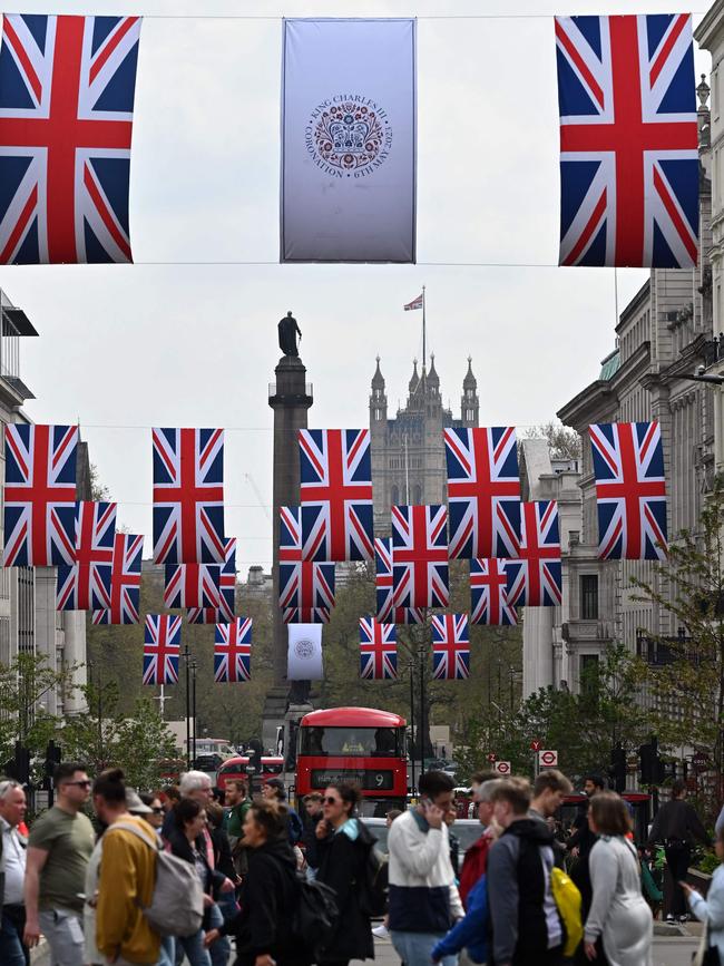 People walk beneath Union flags and Coronation Emblem flags in central London. Picture: AFP