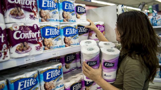 A woman buys toilet paper at a supermarket in Santiago on October 29, 2015. The biggest producers of toilet paper and napkins of Chile shared the market and set prices for a decade, in a new corruption case that has outraged Chilean consumers. The companies CMPC Tissue and SCA Chile, controlling 90% of the market for toilet tissue, are under investigation by the National Economic Prosecutor (FNE). AFP PHOTO / MARTIN BERNETTI