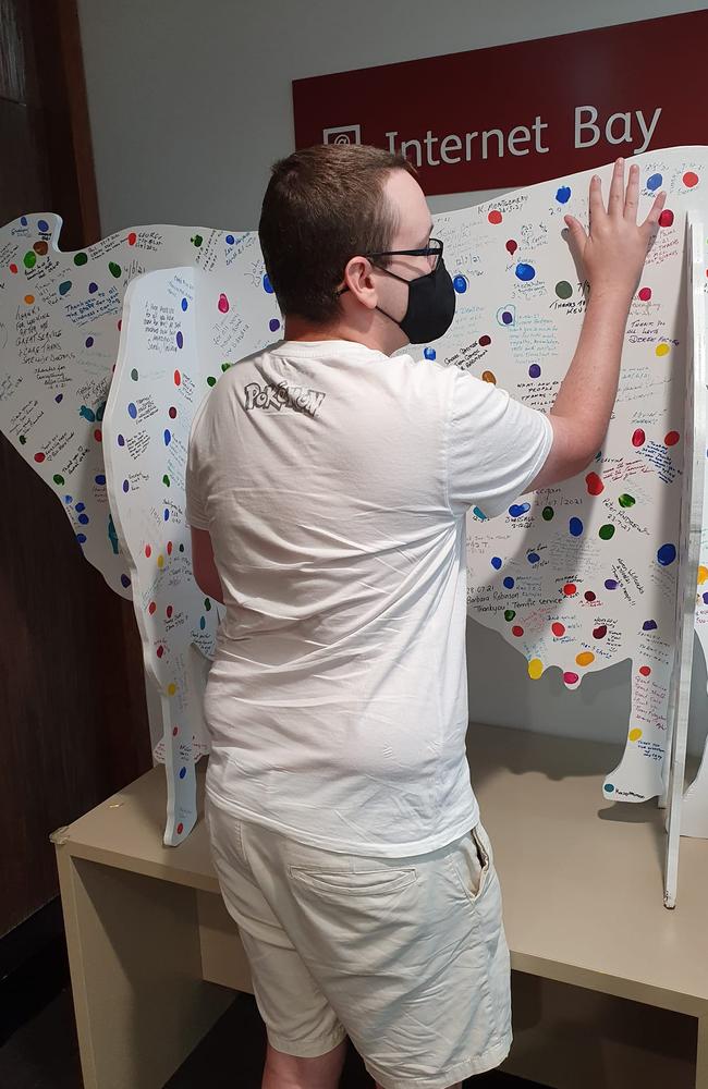 Signing his name on the cancer remission board.