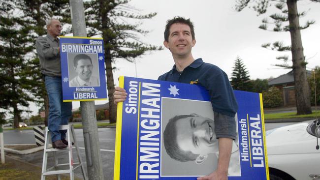 Political candidate Simon Birmingham with stepfather Jim Birmingham hanging election campaign posters at Glenelg North. PICTURE: Toby Zerna