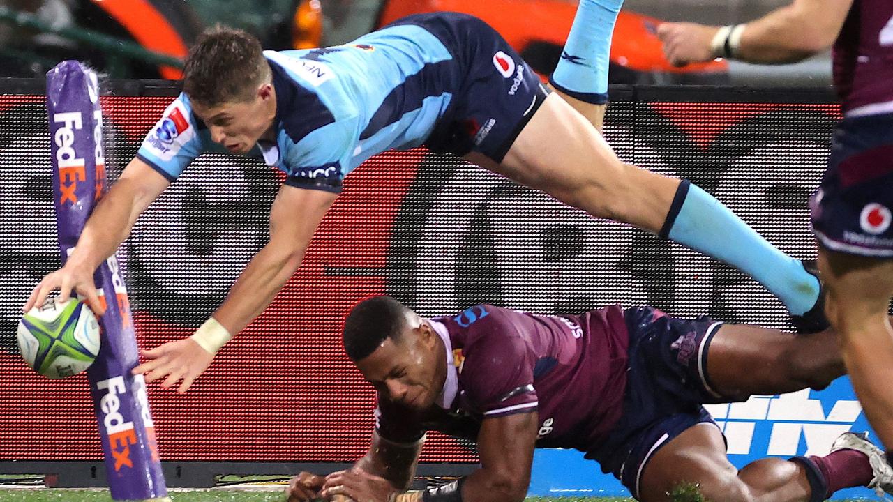 Waratah’s flyer Alex Newsome dives over Reds Filipo Daugunu last weekend. (Photo by DAVID GRAY / AFP)