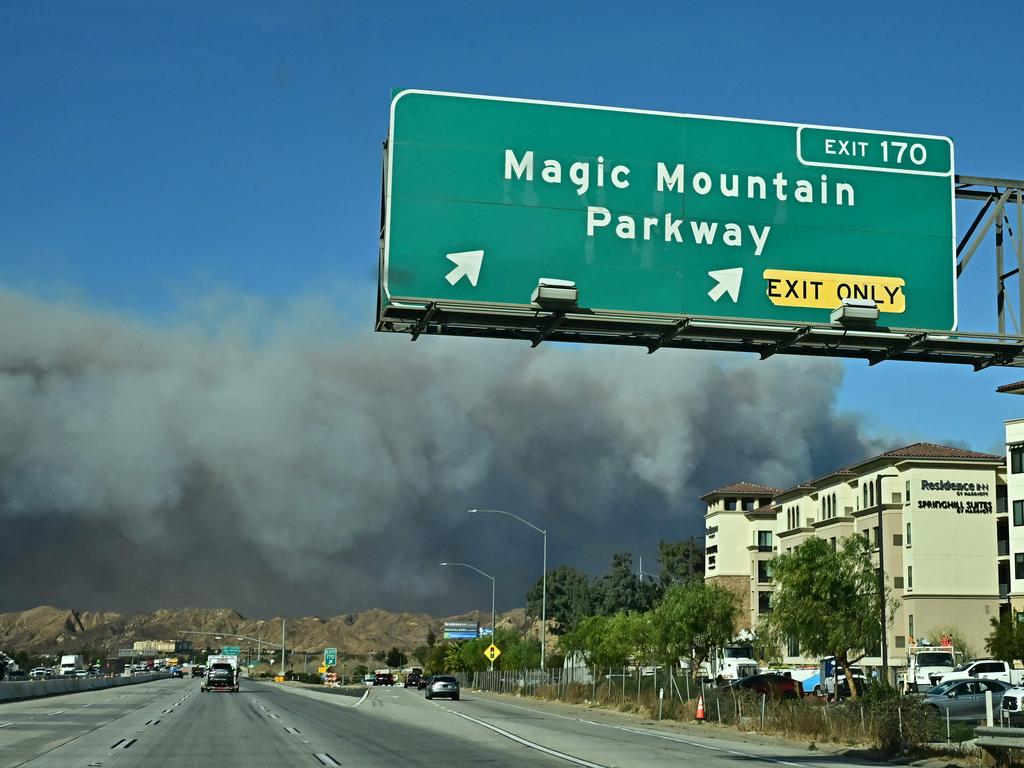 A plume of smoke from the new Hughes fire is seen above the hills from the Magic Mountain exit of Interstate 5 freeway in Valencia, California. Picture: AFP