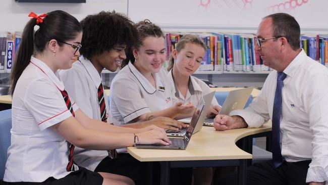 Ponds High School students Leeya Alves, left, Derell Akrong, Mikaela Rumi Badger and Blake Spencer try out the NSWEduChat bot with deputy principal James Laird.