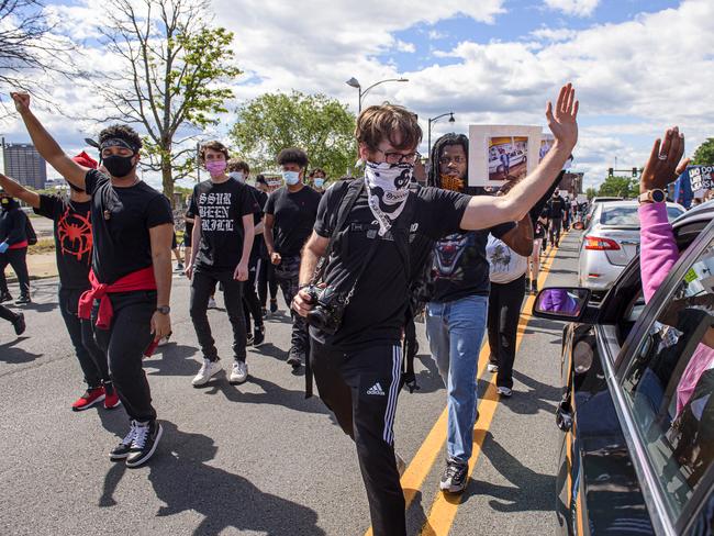 A protester high-fives a driver from her stopped car while an estimated 500 or more people march through Hartford, Connecticut. Picture: AP