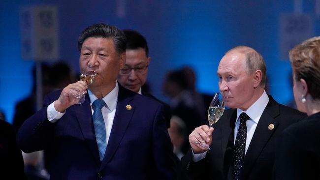 Russian President Vladimir Putin and Chinese President Xi Jinping hold glasses during a festive reception of the BRICS summit in Kazan. (Photo by Alexander Zemlianichenko / AFP)