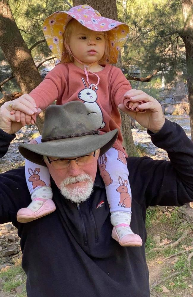 Nigel Harris with his granddaughter Evelyn. The 60-year-old was tragically killed when a vehicle veered off the road and into spectators at the Finke Desert Race. Picture: Facebook.