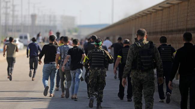 Palestinians and militants from the Ezzedine al-Qassam Brigades run towards the Erez crossing between Israel and the northern Gaza Strip. Picture: AFP