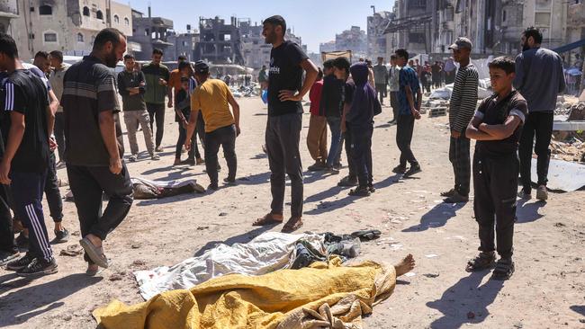 Palestinians stand over the shrouded bodies of people killed during an Israeli drone strike in Jabalia, in the northern Gaza Strip on Friday. Picture: Bashar Taleb/AFP