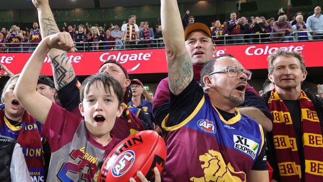 Lions fans celebrate after defeating the Blues in the preliminary final match at the Gabba. Picture Lachie Millard