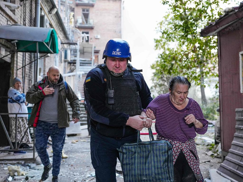 A rescuer helping a woman following strikes on the Ukrainian capital of Kyiv, amid Russia's invasion of Ukraine. Picture: AFP