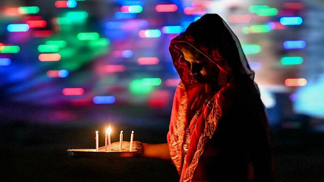A woman lights candles in front of her house during the celebrations to mark Diwali, the Hindu festival of lights, in New Delhi. ‘At sumptuous Diwali parties, a feast is laid out. But the hostess, who has top chefs working for her at home, pulls out a box and pops a handful of vitamins. That’s her dinner.’ Picture: Arun Sankar / AFP
