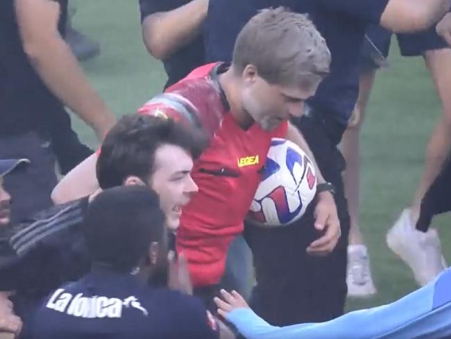 17/12/2022 referee Alex King tries to leave the ground as fans stormed the pitch during the round eight A-League Men's match between Melbourne City and Melbourne Victory at AAMI Park. Picture:  Fox Sport