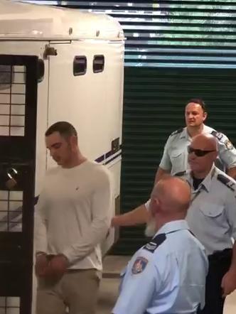 Mathew Flame is led to a police van in handcuffs for questioning. Picture: Toby Zerna