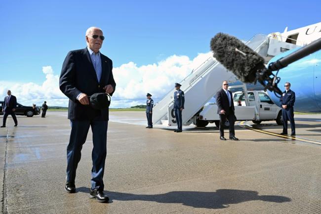 US President Joe Biden walks to speak with the press before boarding Air Force One prior to departure from Dane County Regional Airport in Madison