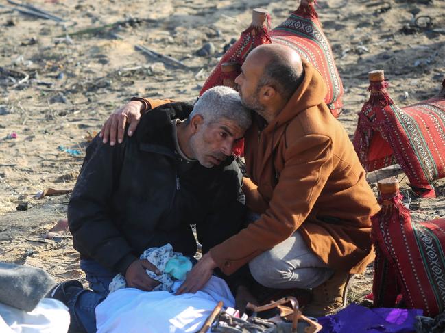 A man is comforted by another man as people inspect the damage to their homes following Israeli air strikes in Rafah, Gaza. Picture: Getty Images