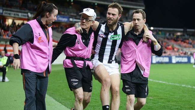 Magpie Brent Macaffer is helped from the field. Picture: Getty