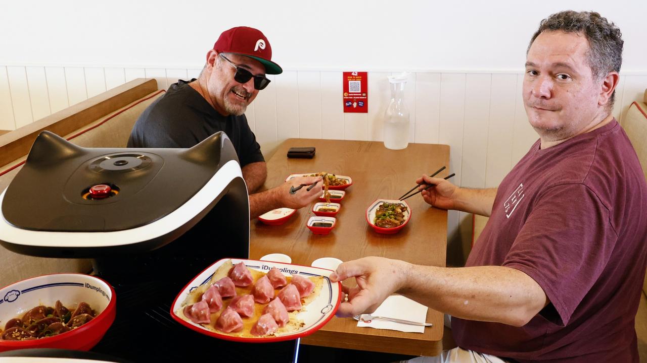 Diners Troy Woosnam and Wayne Lavis have their lunch delivered by robot at the new Impressive Dumplings restaurant. Picture: Brendan Radke