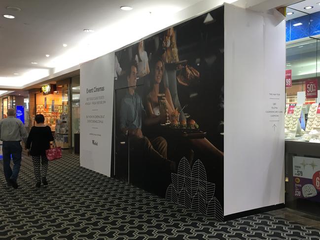 Shoppers walk past one of more than a dozen stores boarded up outlets at Westfield Carindale. Pic: The Courier-Mail