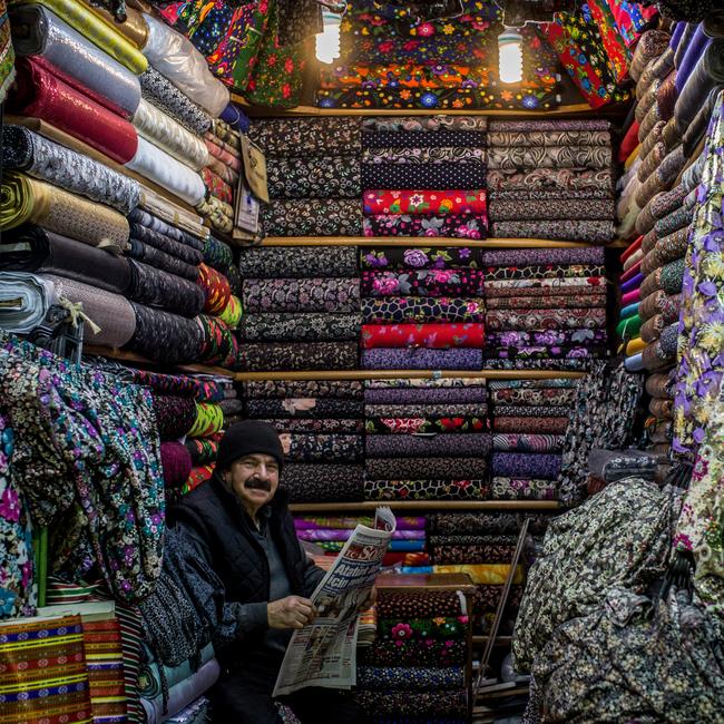 Kenan Kalmaz poses for a photograph inside his families store selling traditional fabrics inside the Istanbul Grand Bazaar.