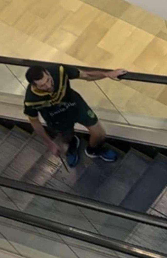 The attacker dressed in a Kangaroos jersey was seen with a large knife on the escalator. Picture: Twitter