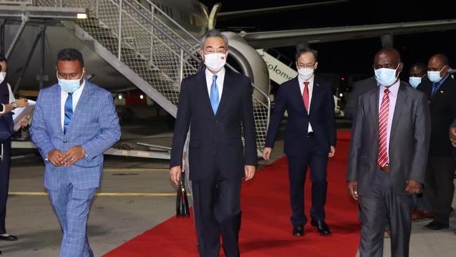 Solomon Island's Foreign Minister Jeremiah Manele, left, and Chief Protocole Walter Diamana, right, escorting Chinese Foreign Minister Wang Yi, centre, upon his arrival in Honiara. Picture: AFP