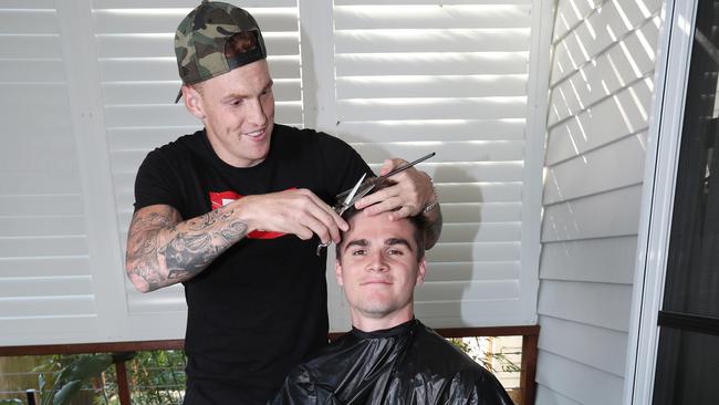 Mitch Robinson cutting the hair of teammate Ben Keays