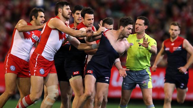 Swans players remonstrate with Melbourne's Tomas Bugg after an off the ball incident with Callum Mills. Pic: Michael Klein