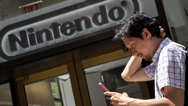 A man plays Pokemon Go on his smartphone outside of Nintendo's flagship NYC store. Picture: Drew Angerer