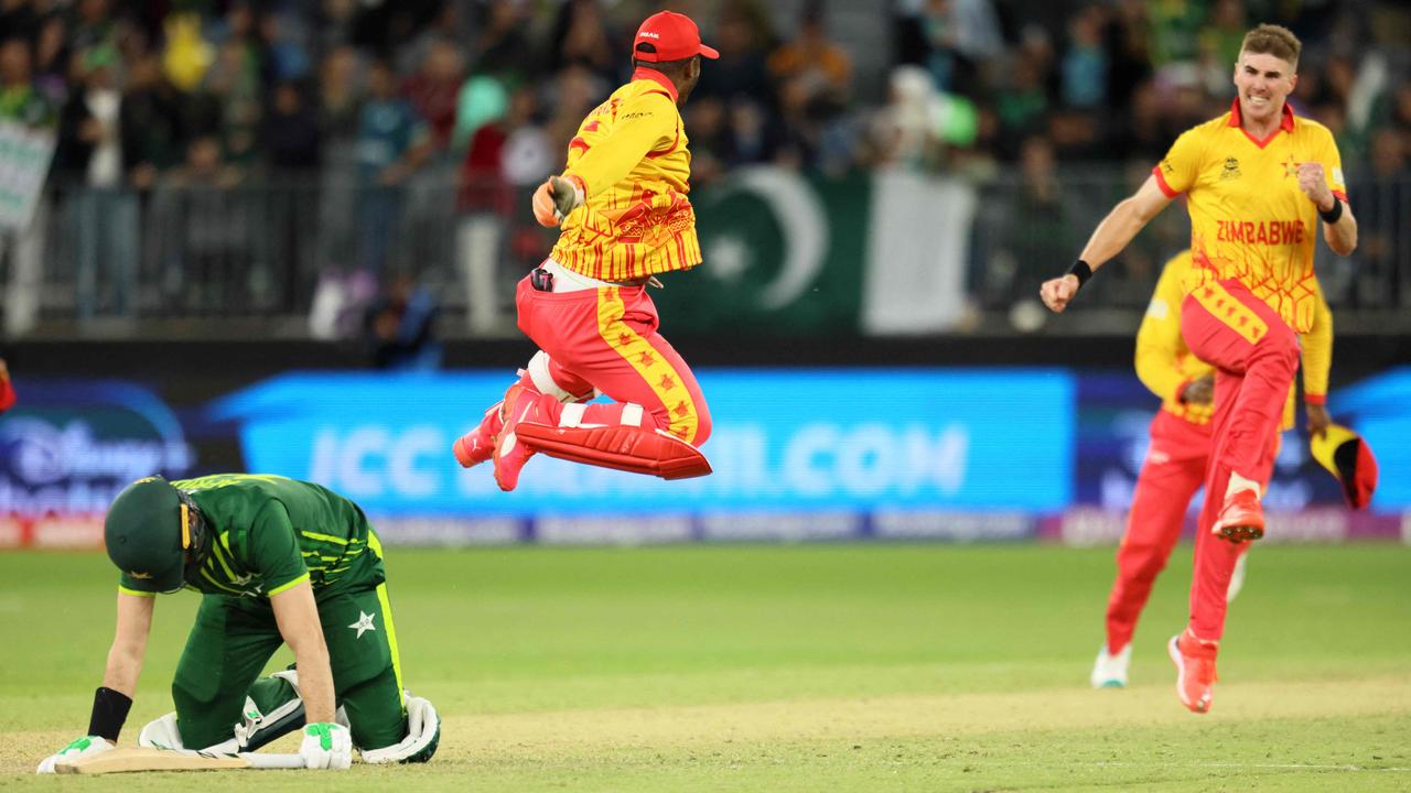 Zimbabwe's players celebrate their victory as Pakistan's Shaheen Shah Afridi (L) lies on the pitch.