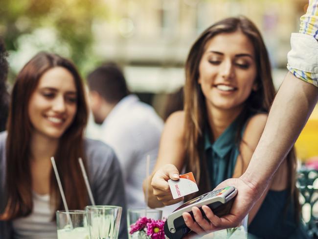 Young women having drinks in cafe making a payment with credit card Picture: istock